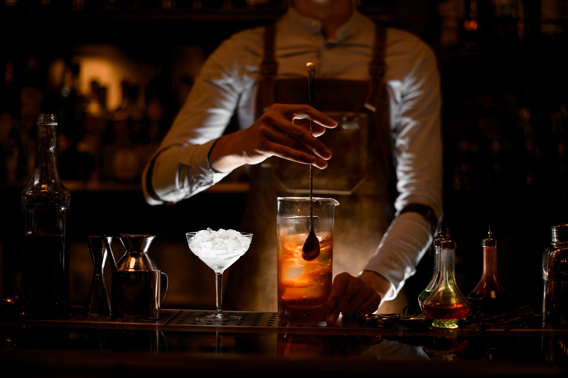 Bartender stirring alcohol cocktail with a spoon